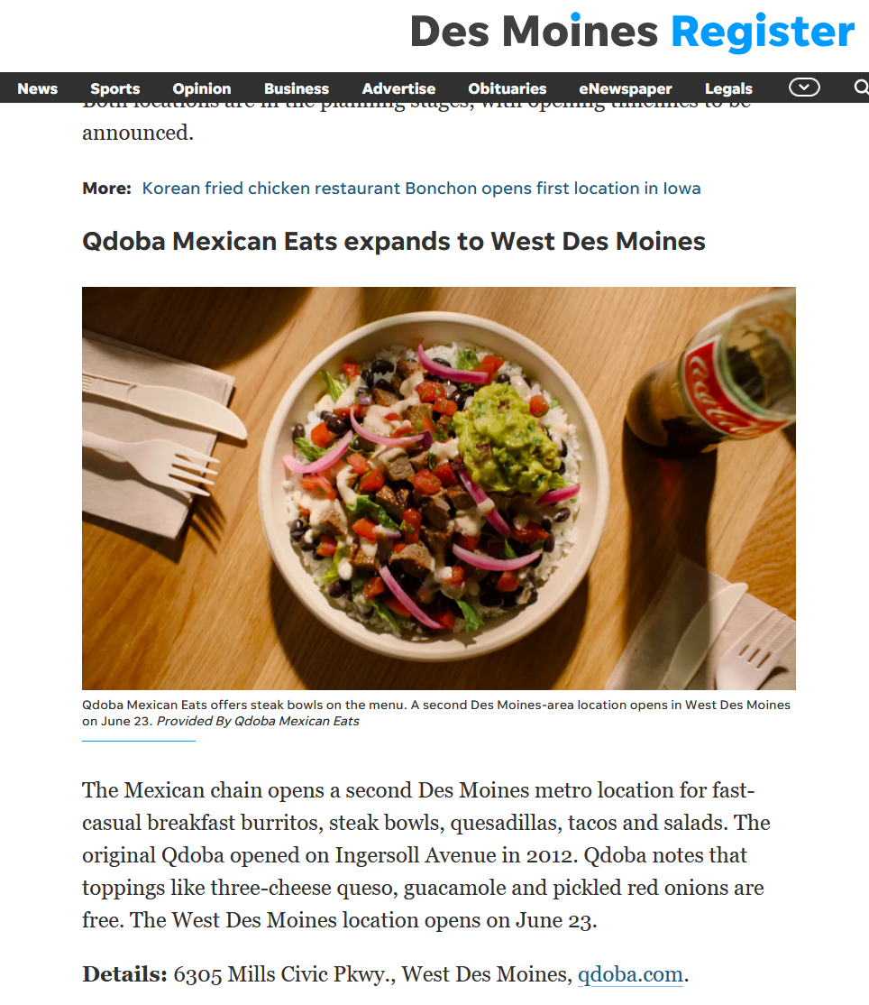 Overhead view of a QDOBA Mexican Eats steak bowl topped with guacamole, pickled red onions, pico de gallo, black beans, rice, and queso on a wooden table. A glass bottle of Coca-Cola and compostable utensils sit beside the bowl.