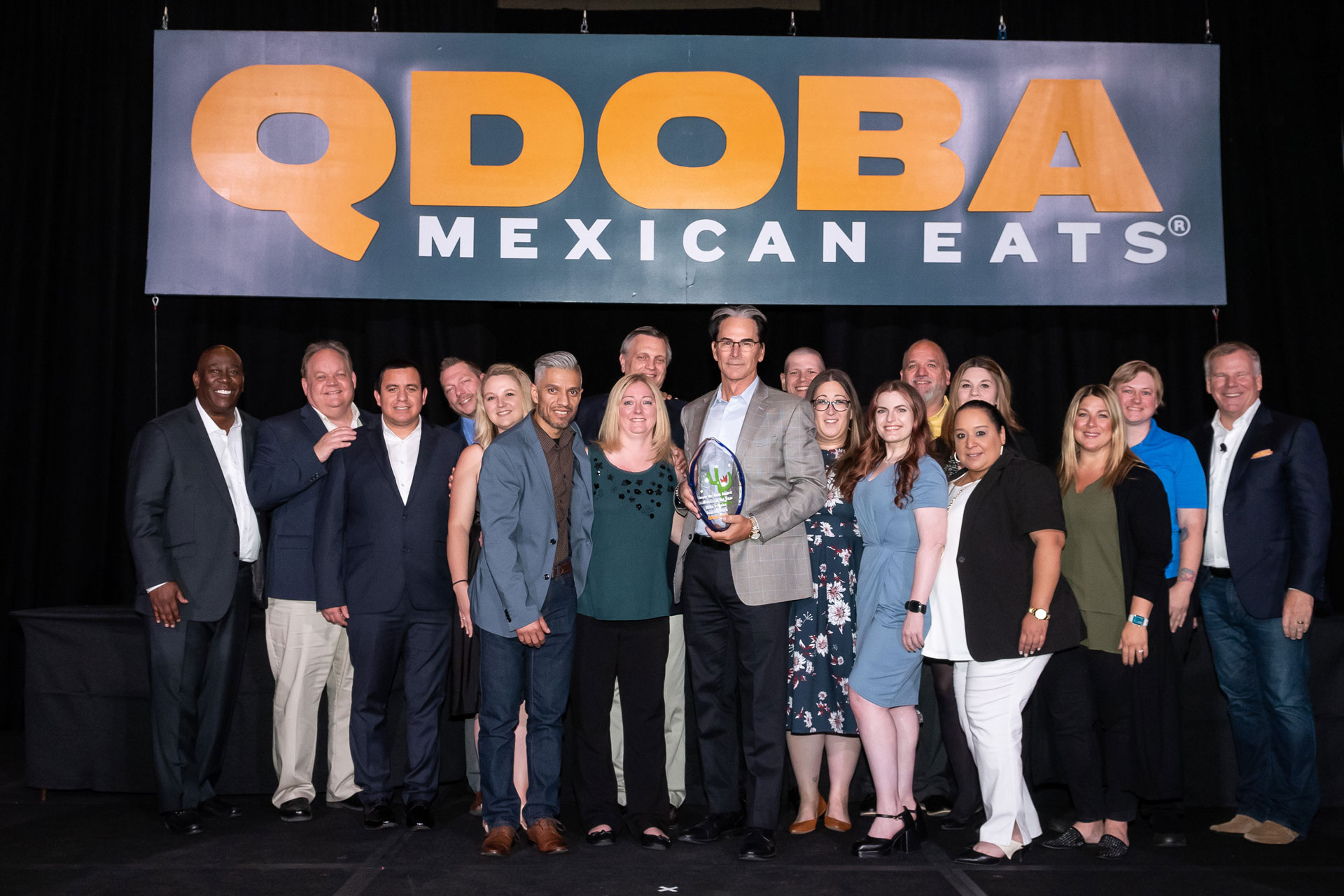 Roaring Fork Restaurant Group team members receiving the Franchisee of the Year award at the 2023 QDOBA Brand Conference in Las Vegas, Nevada, showcasing their exceptional achievements and dedication to excellence in the restaurant industry.